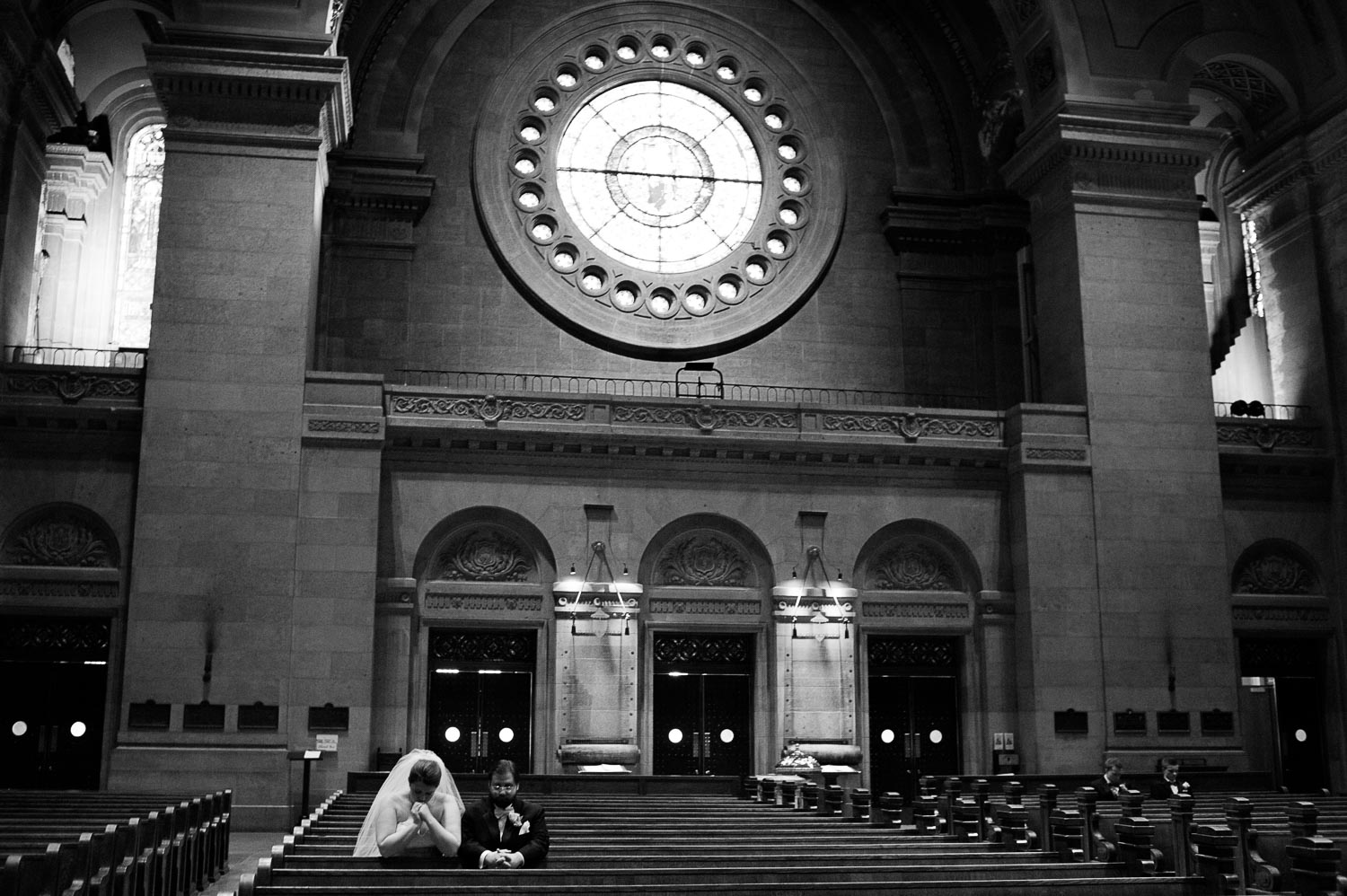 bride and groom praying before their wedding at The Basilica of Saint Mary in Minneapolis