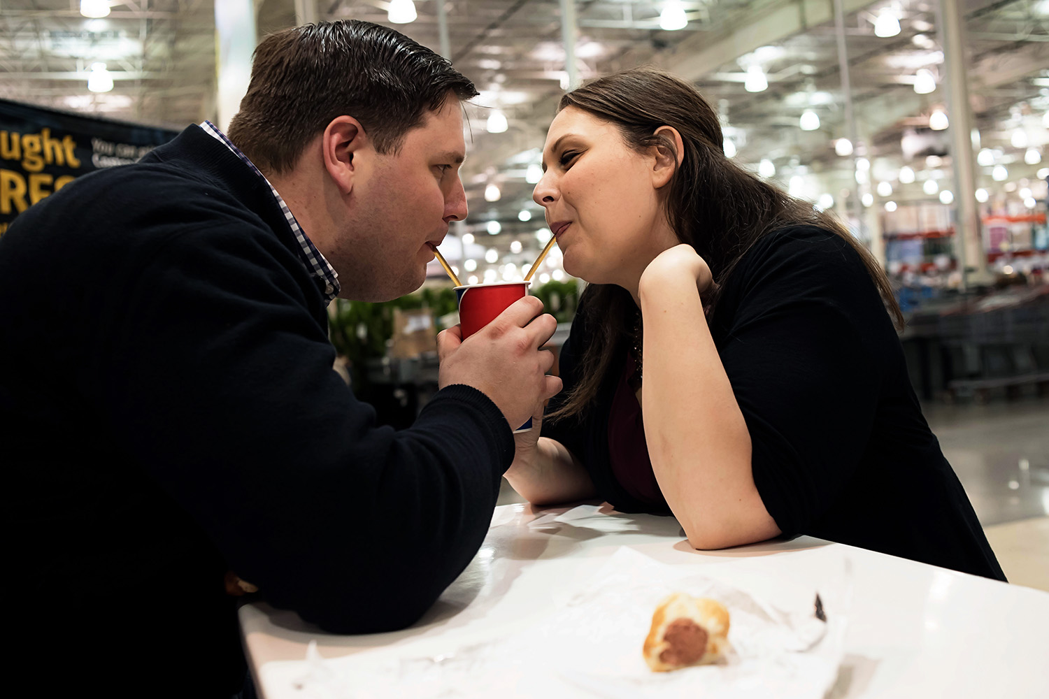 Couple sharing a soda together during their engagement session