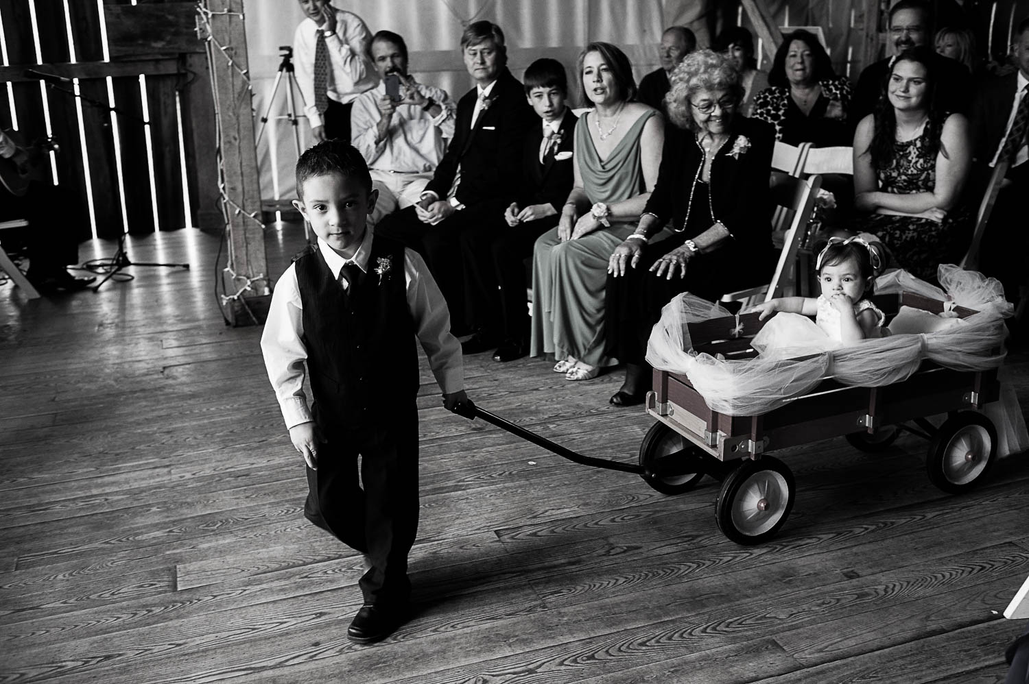 ring bearer and flower girlbeing pulled in a wagon at the