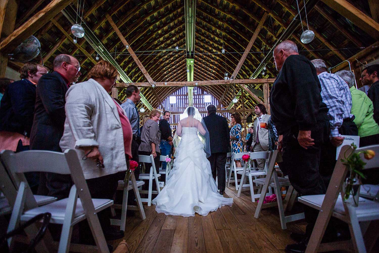 bride walking down the aisle during the processional at the Enchanted Barn wedding