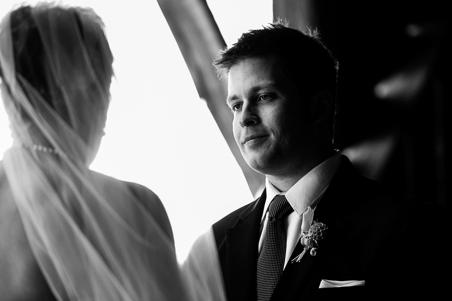 groom looking at bride during their wedding ceremony at the Enchanted Barn