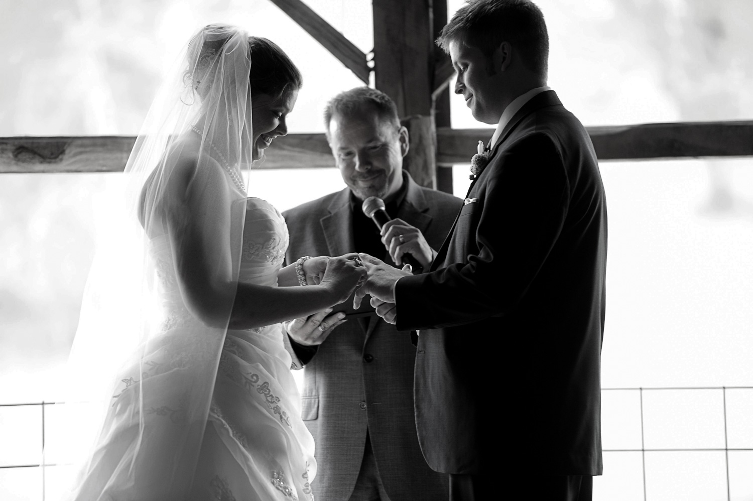 bride and groom exchanging rings during their Enchanted Barn wedding