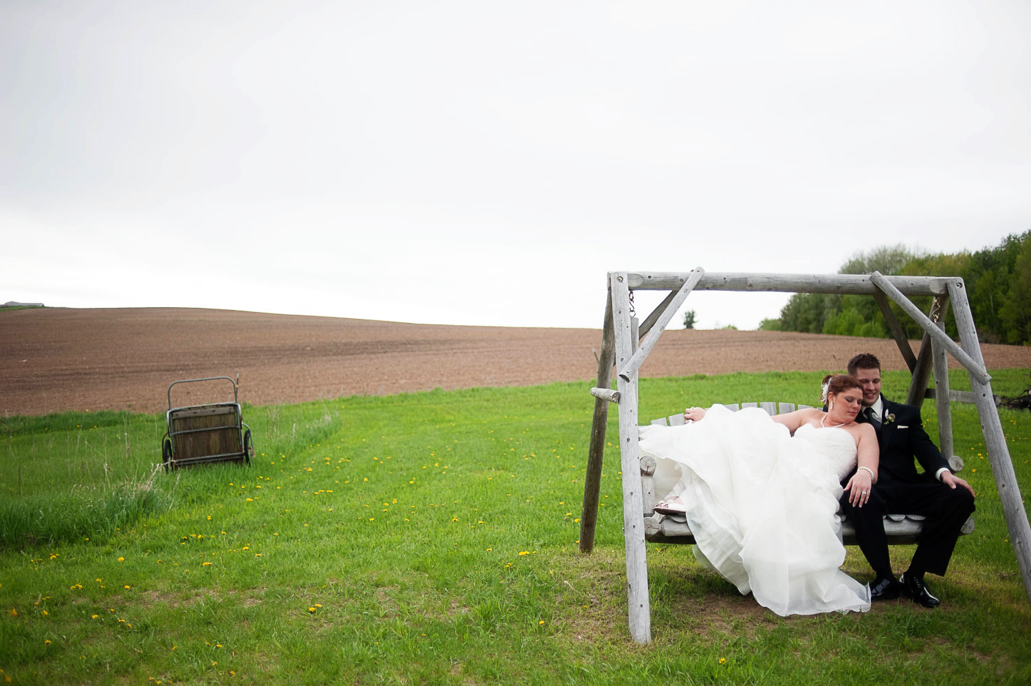 bride and groom on a swing at the Enchanted Barn in Wisconsin