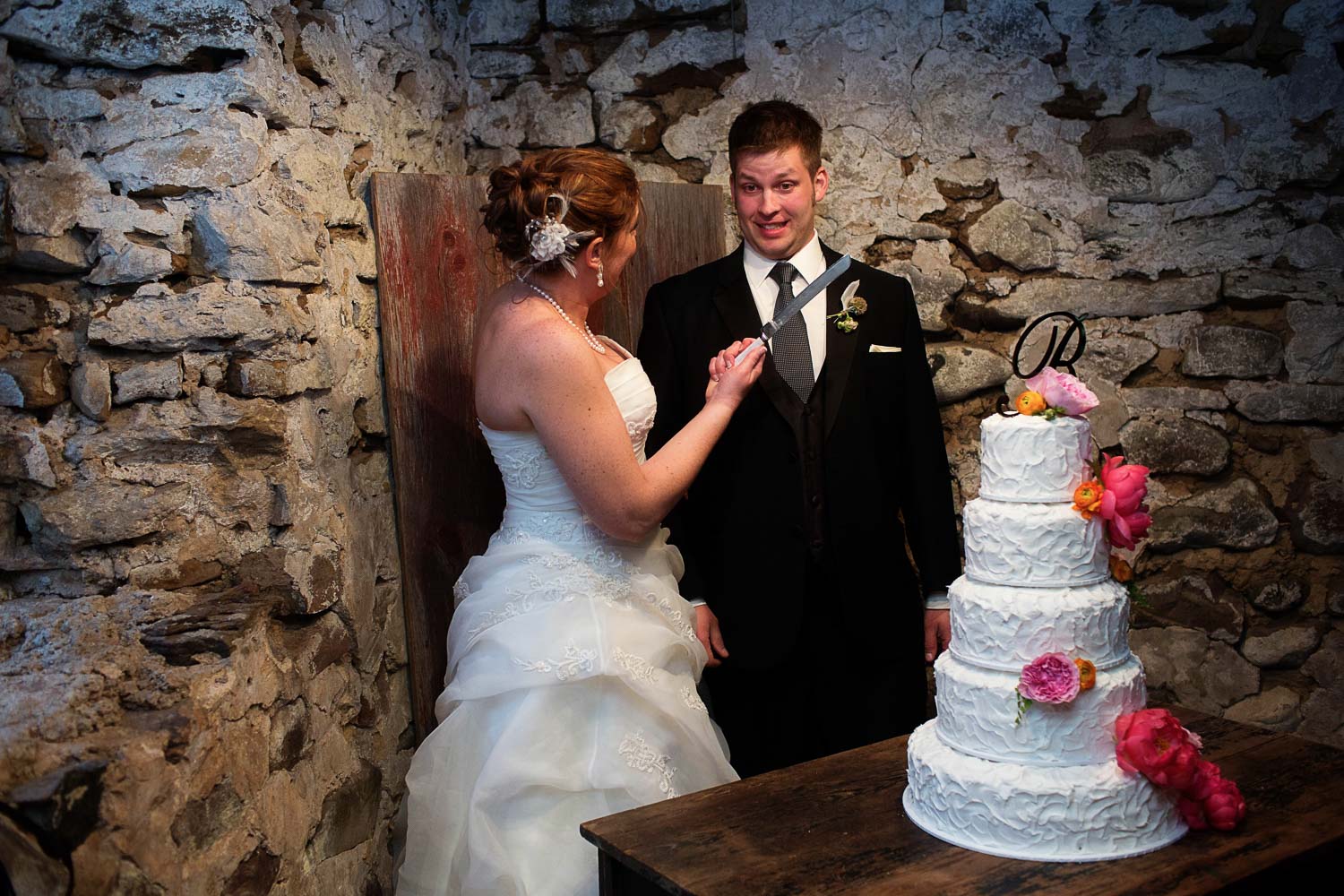 bride and groom cutting the cake at the Enchanted Barn wedding
