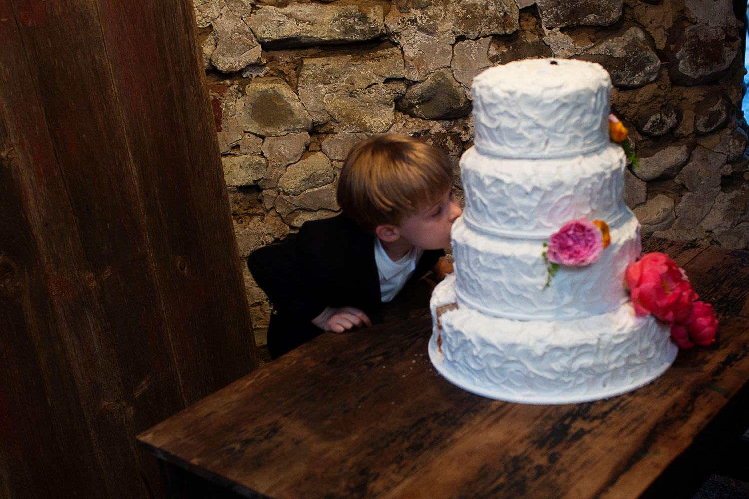 kid licking the wedding cake at the Enchanted Barn in Wisconsin