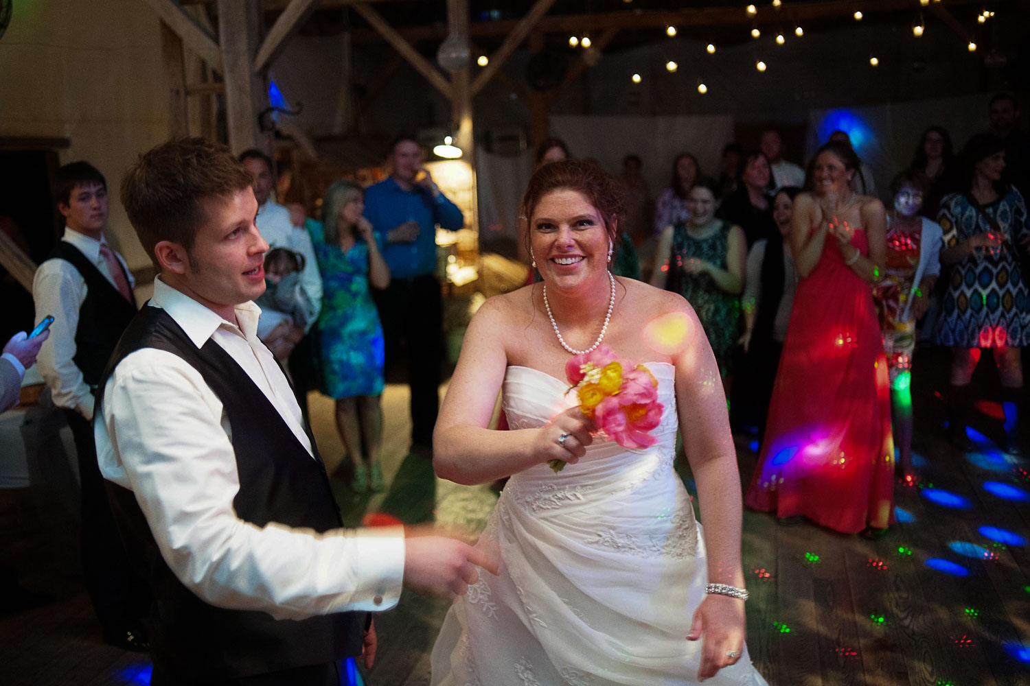 bride tossing the bouquet at the Enchanted Barn wedding