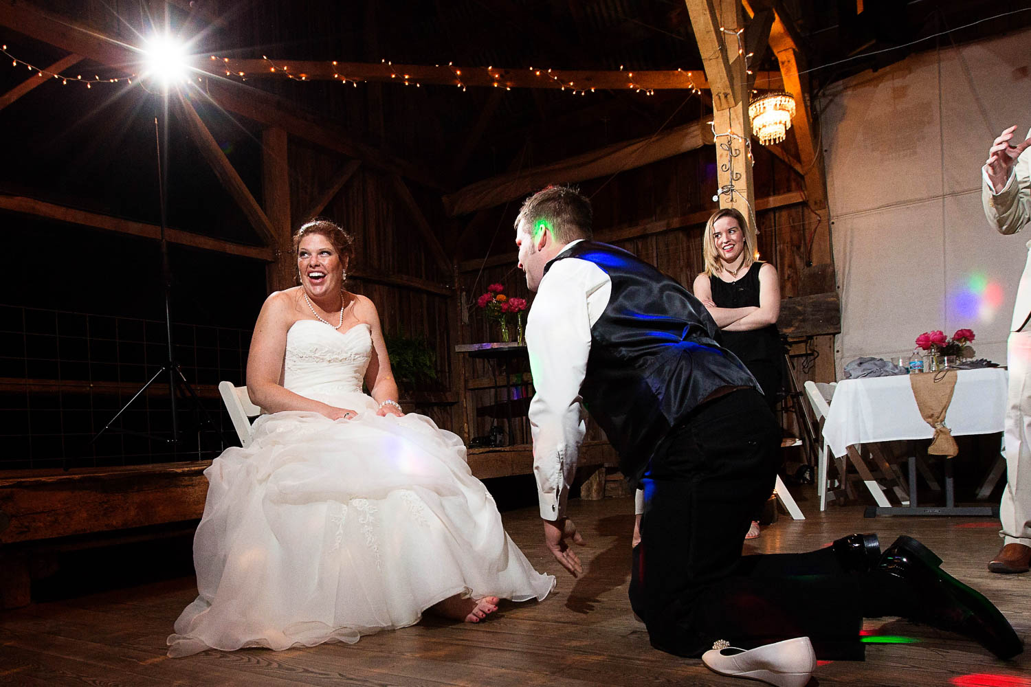 groom taking the garter off his bride at the Enchanted Barn