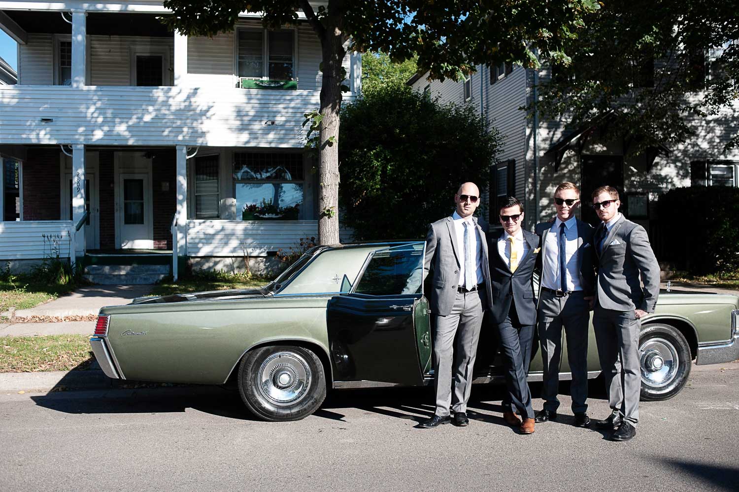 groomsmen hanging out by a classic car