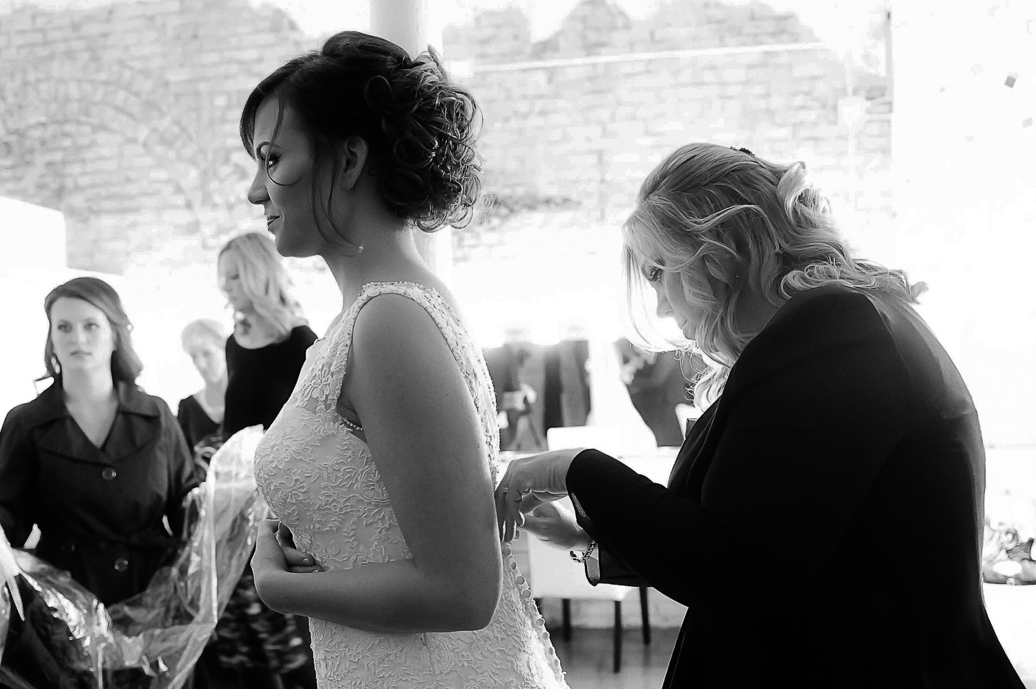 mom helping bride with her dress in the dressing room at Aria in Minneapolis