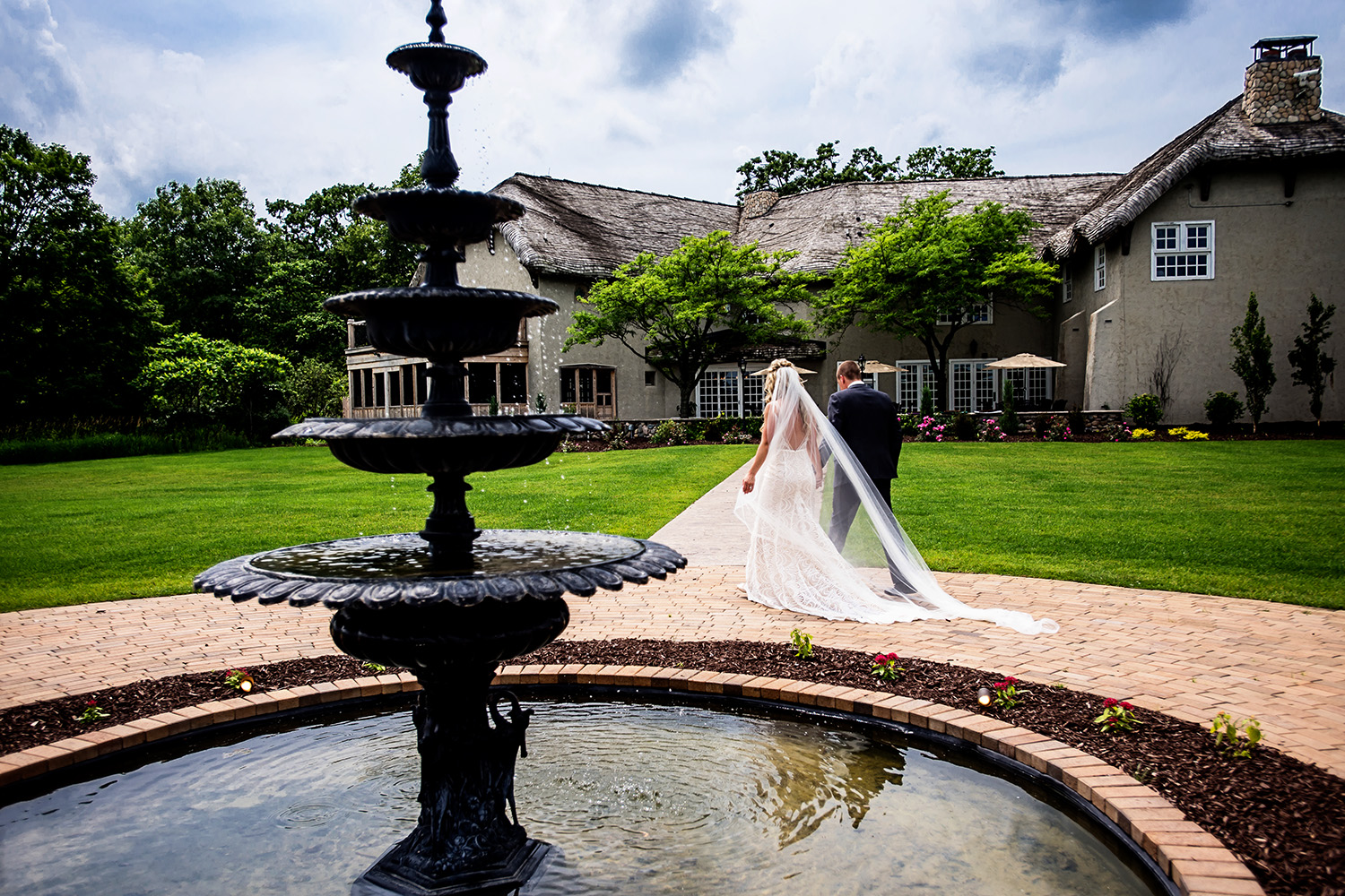bride and groom walking by a fountain at Bavaria Downs 