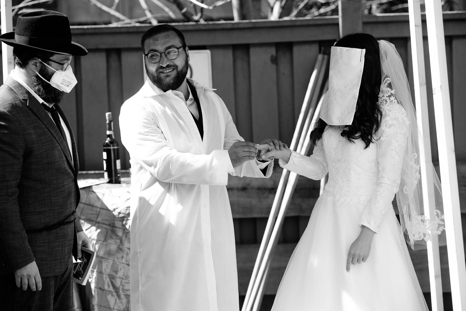 Jewish bride and groom exchanging rings under the chuppah during their covid-19 wedding in Minneapolis