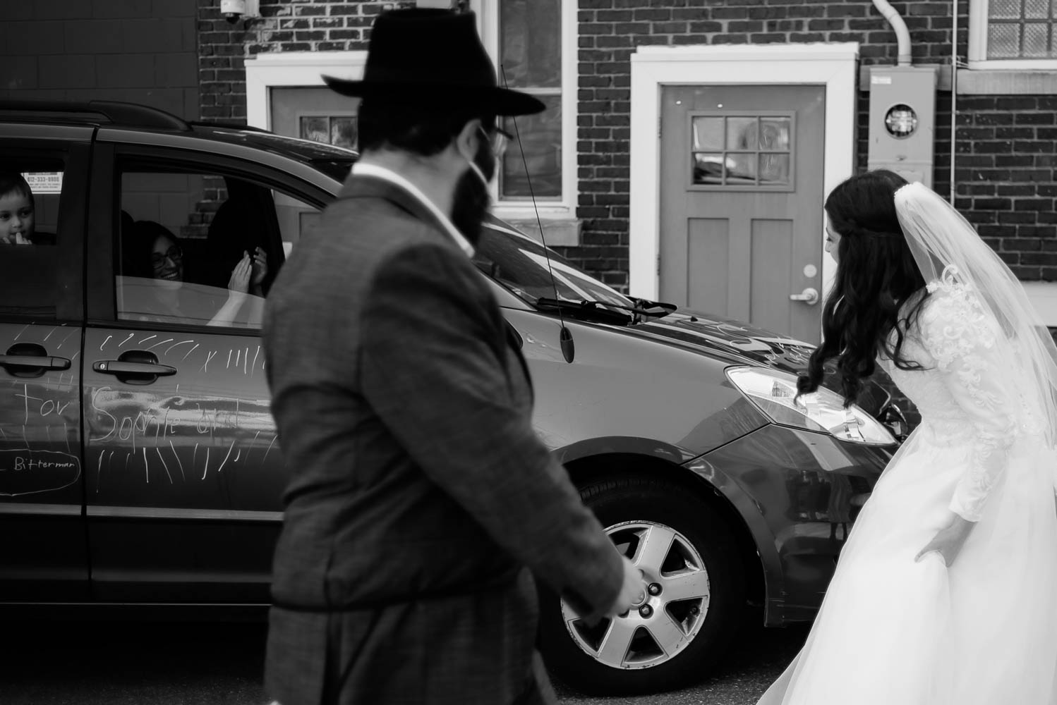 Jewish guests sitting in cars to watch the covid-19 wedding
