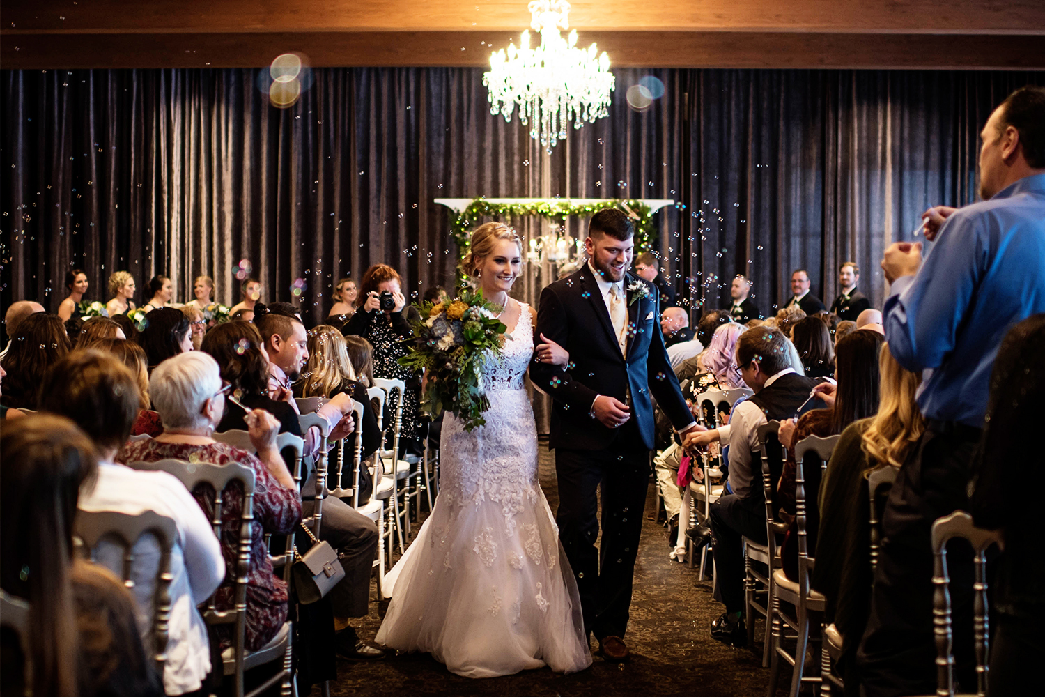 bride and groom walking down the aisle after the ceremony through bubbles