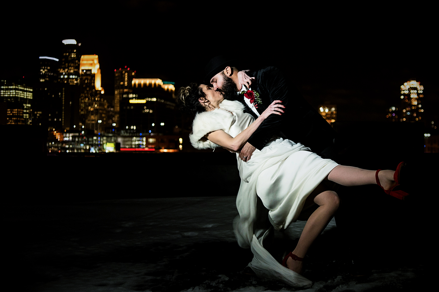 bride and groom on the rooftop at night with the city of Minneapolis skyline