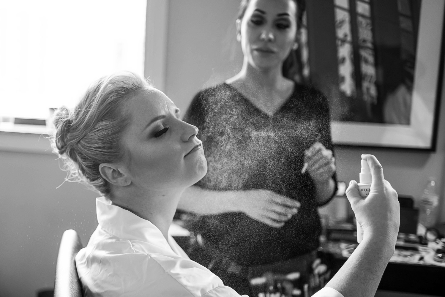 bride spraying perfume while getting ready for her wedding