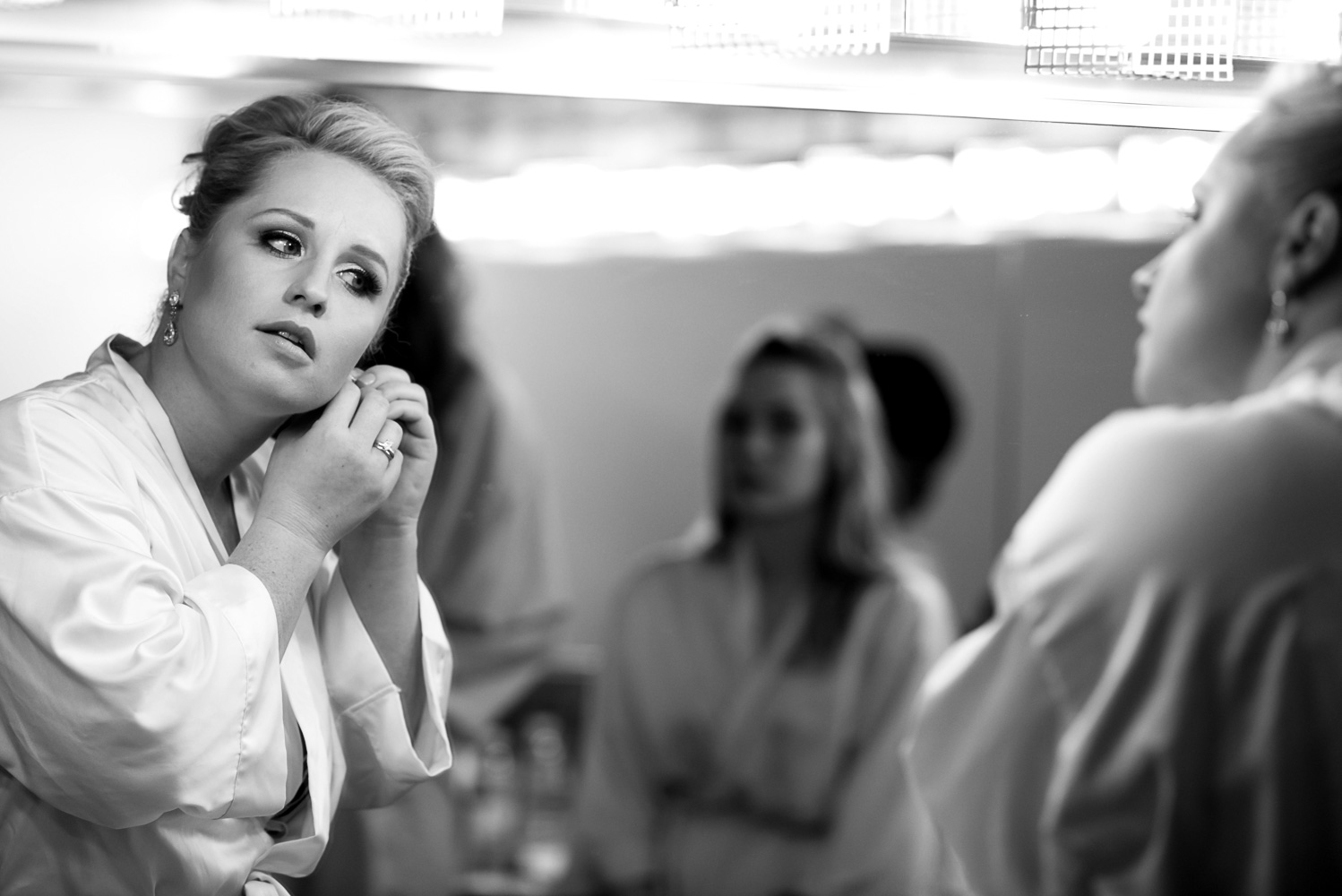 bride putting on jewelry on her wedding day