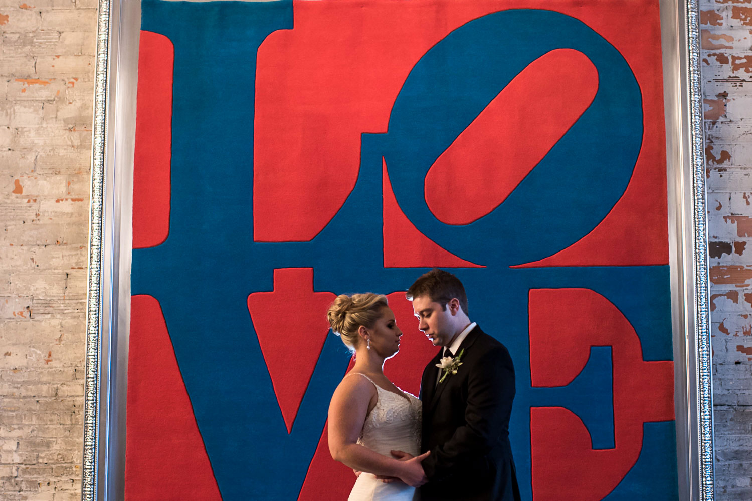 bride and groom standing next to the love picture at Aria in Minneapolis