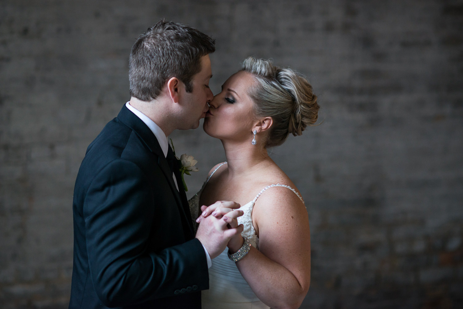 bride and groom holding hands and kissing at Aria in Minneapolis