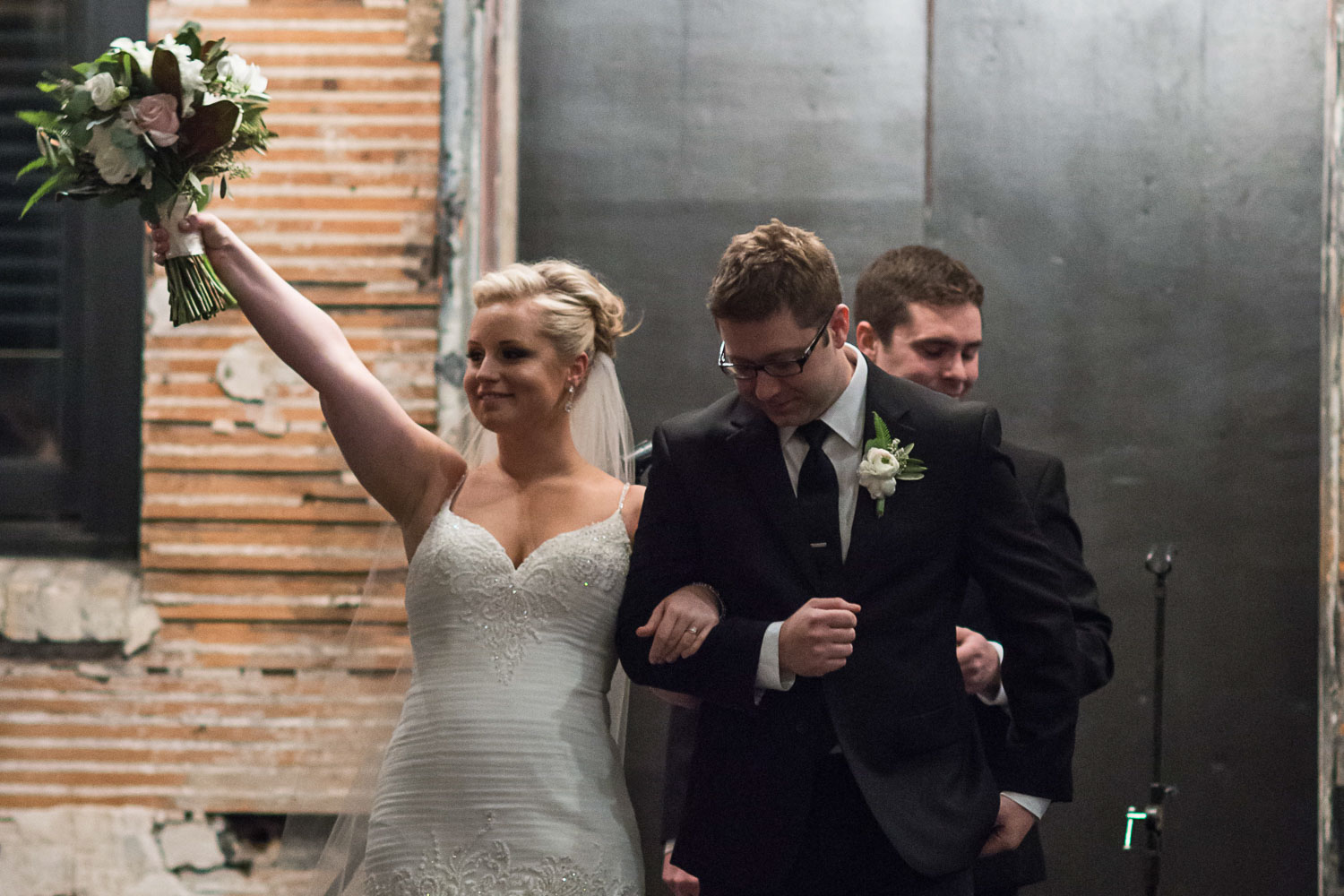 bride raising her bouquet after the wedding ceremony at Aria in Minneapolis