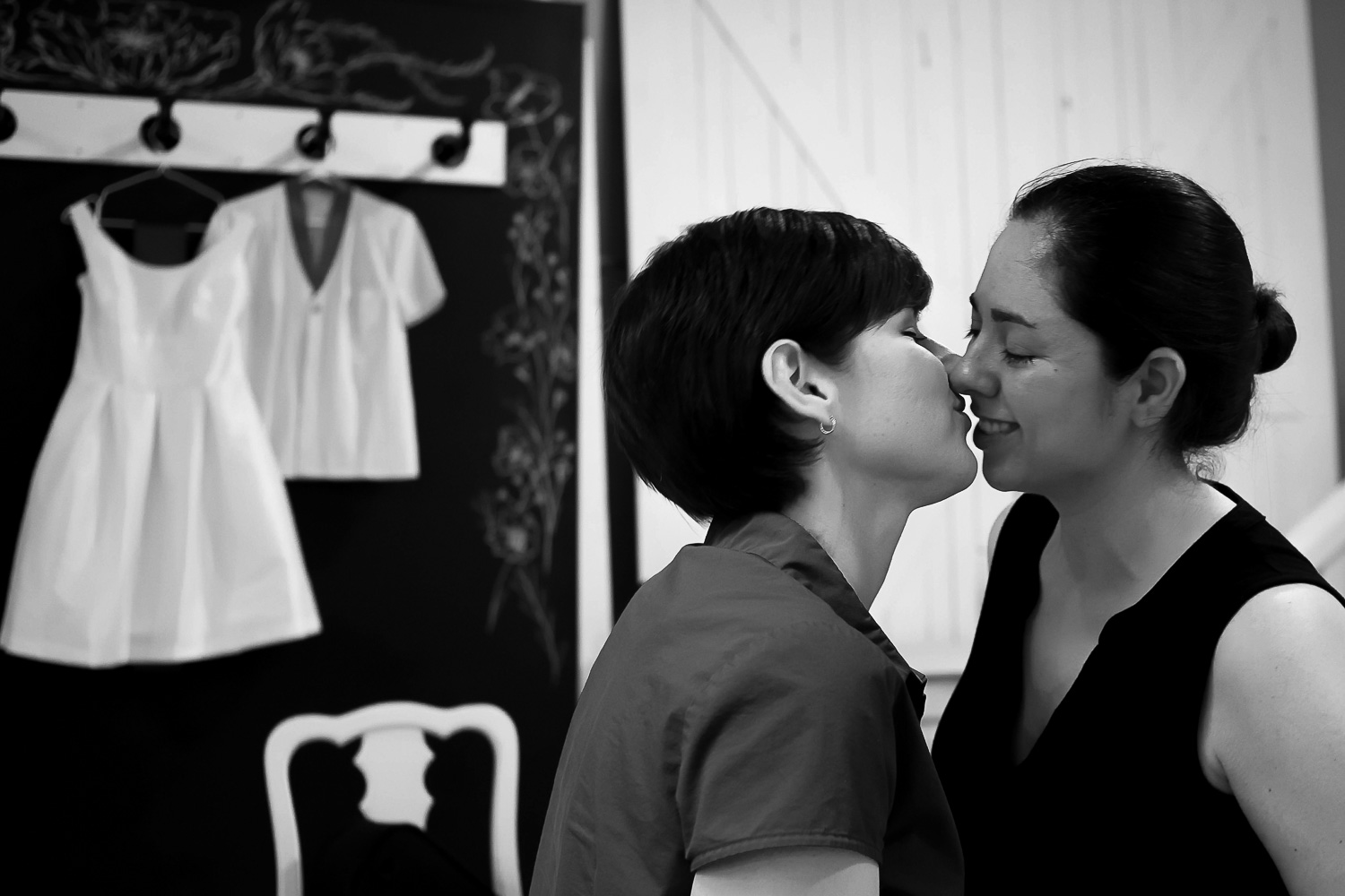 same sex lesbian couple kissing as they get ready in the dressing room of Neu Neu in Minneapolis