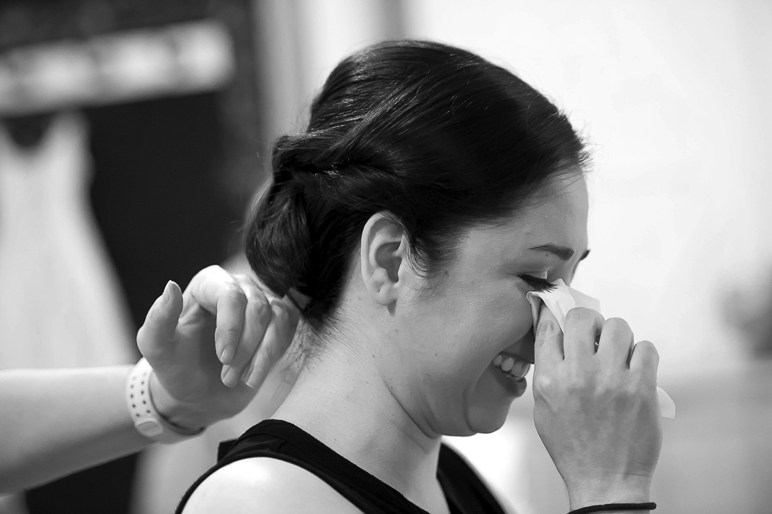 bride wiping away a tear while she listens to a song performed my her bride in Minneapolis