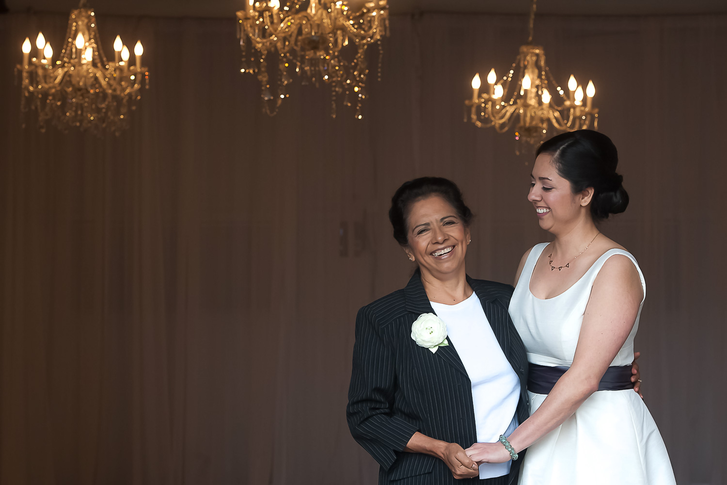 bride and her mom laughing and holding hands at their Minneapolis wedding venue