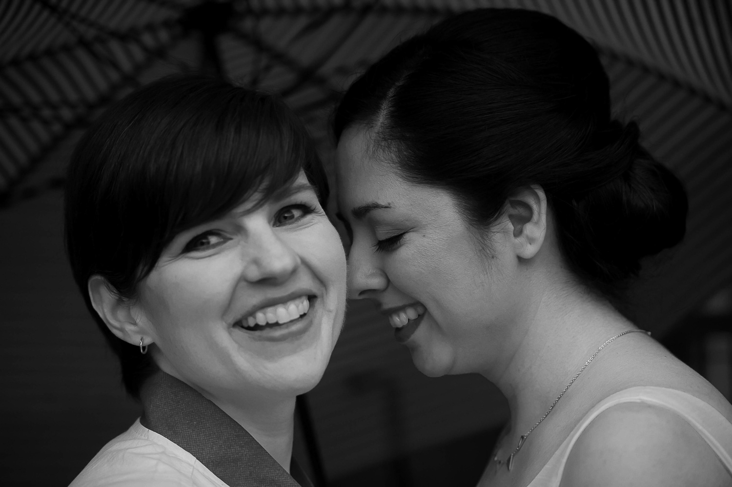 gay couple touching faces in Minneapolis and smiling on their wedding day