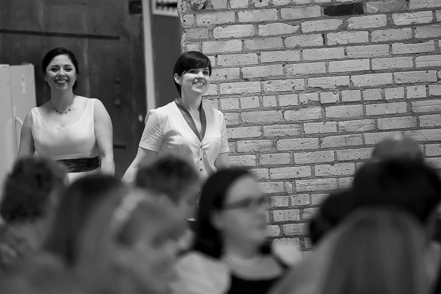 lesbian couple walking down the aisle for their wedding ceremony at Neu Neu in Minneapolis