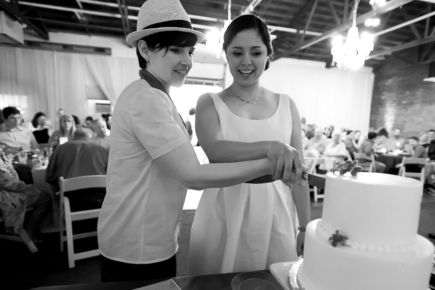 brides cutting the cake during their wedding reception at Neu Neu in Minneapolis