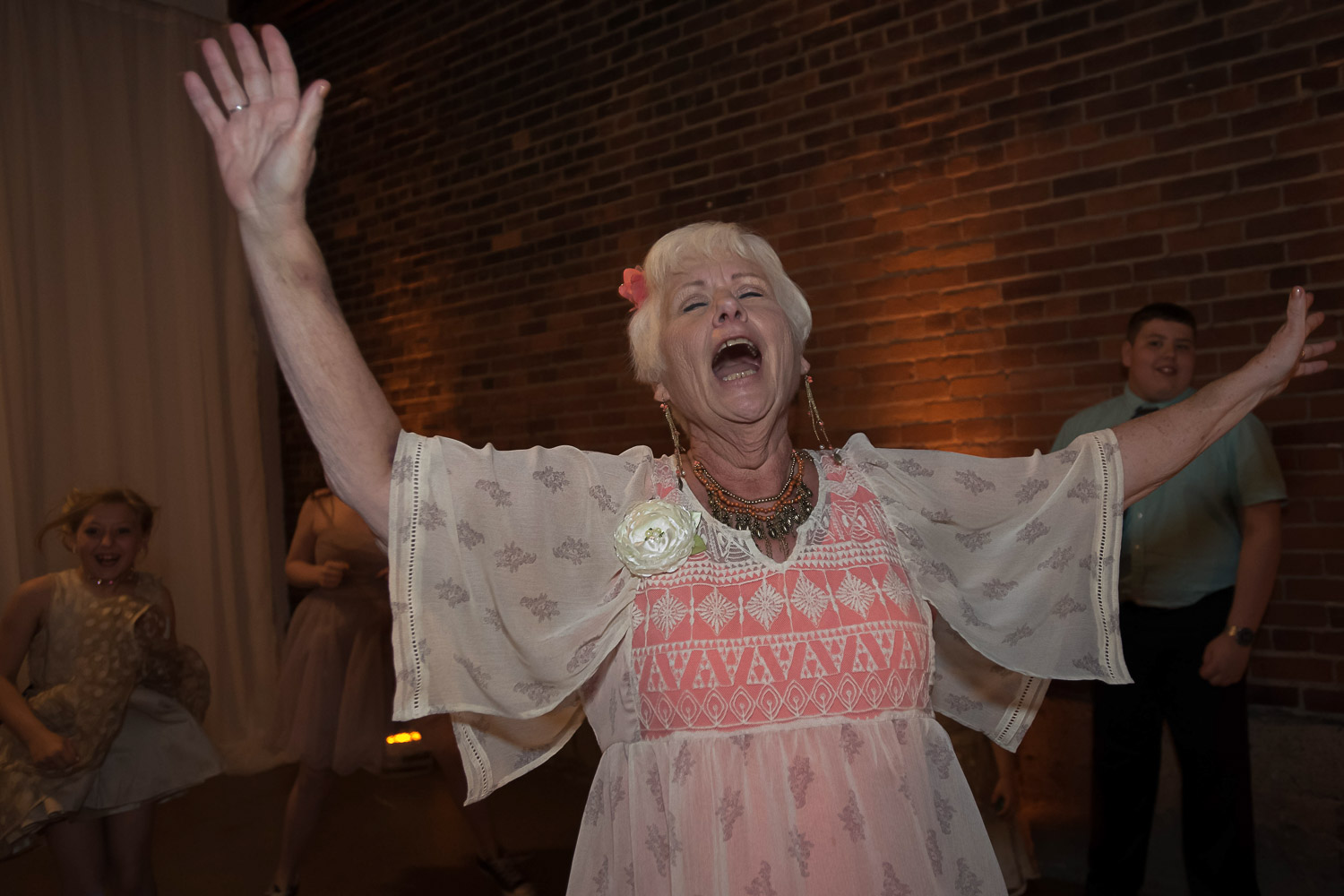 excited wedding guest dancing with her arms in the air at an industrial wedding venue in Minneapolis