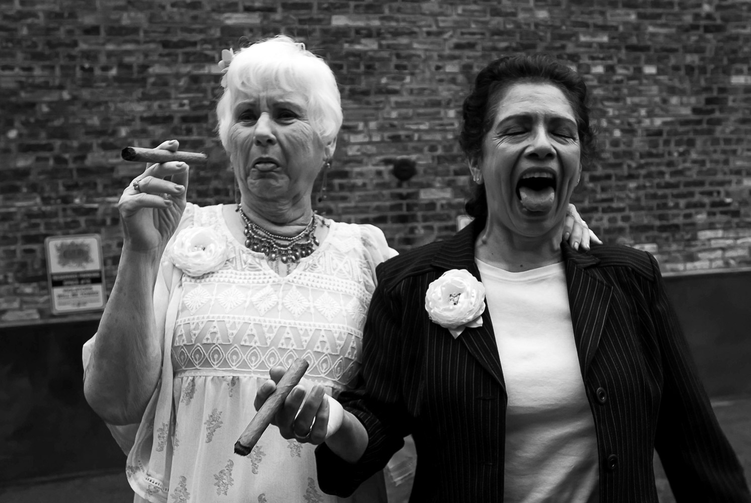 bride's moms making faces after smoking a cigar outside at the wedding reception at Neu Neu