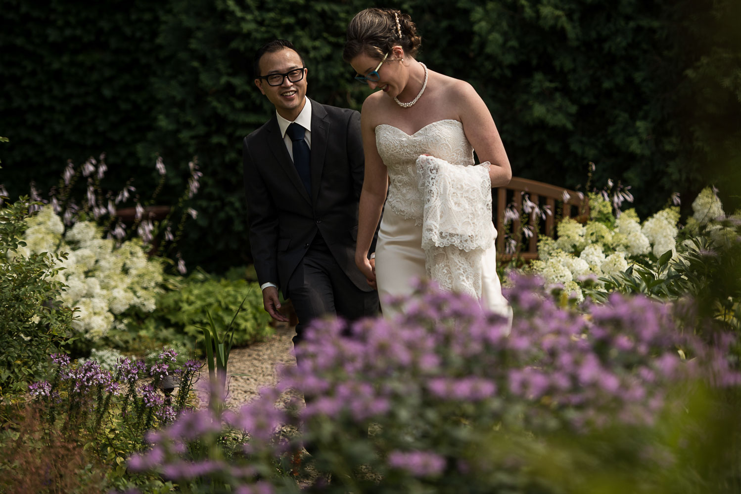 bride and groom walking together holding hands in the garden of the St Paul Hotel