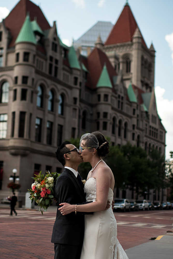 bride and groom kissing in front of the Landmark Center in St Paul