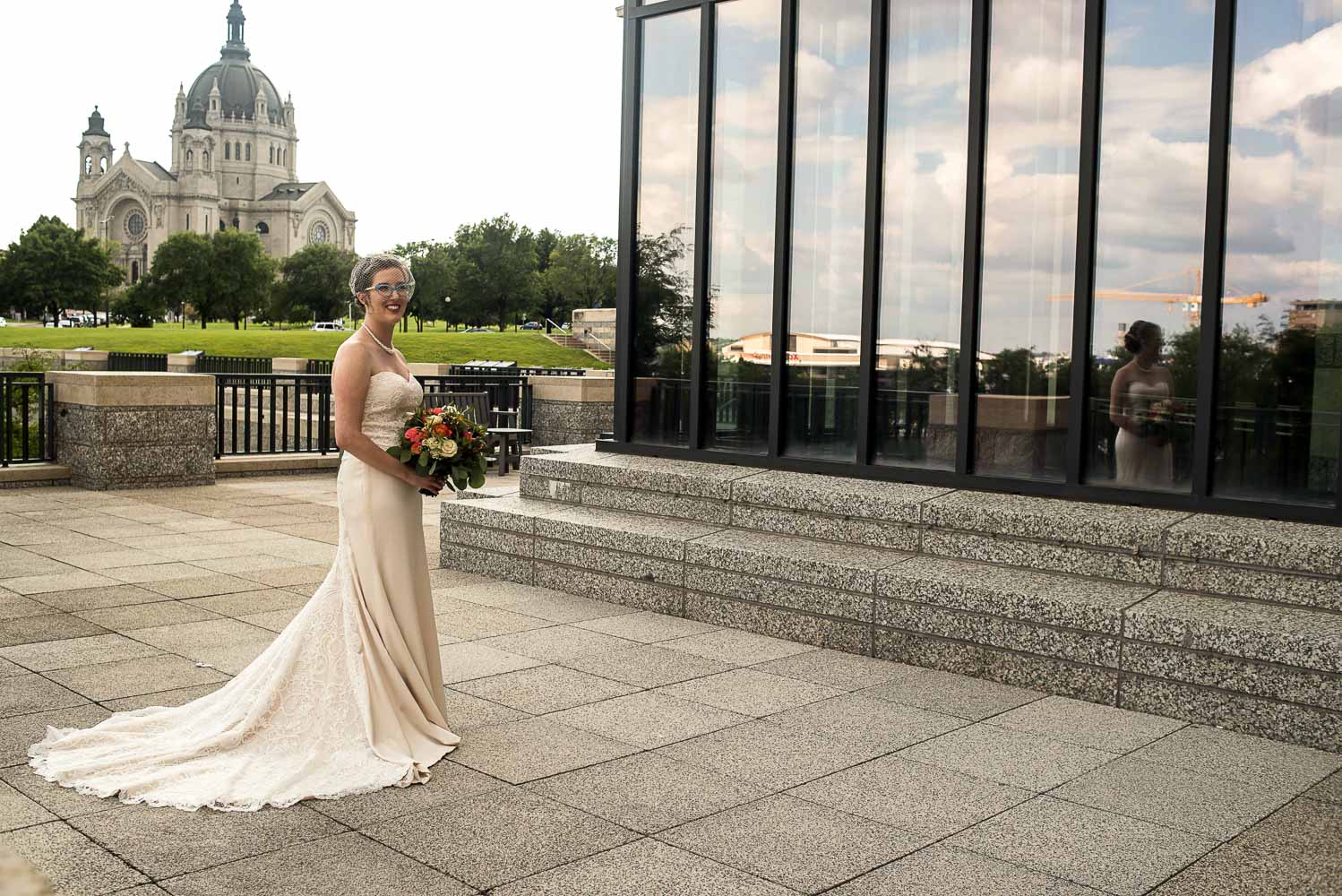 bridal portrait on the balcony of the Minnesota History Center with the Cathedral in the background