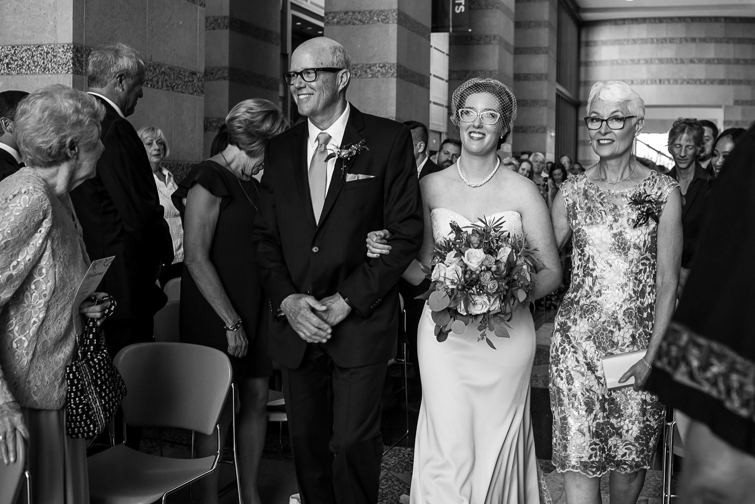 bride walking down the aisle with her parents at the Minnesota History Center