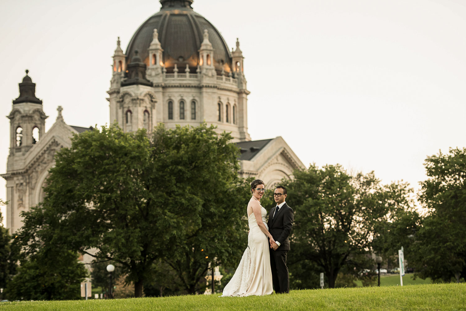 bride and groom on the grass in front of the Cathedral in St Paul