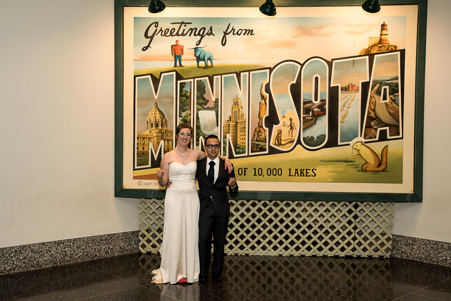bride and groom standing next to the Minnesota sign at the History Center