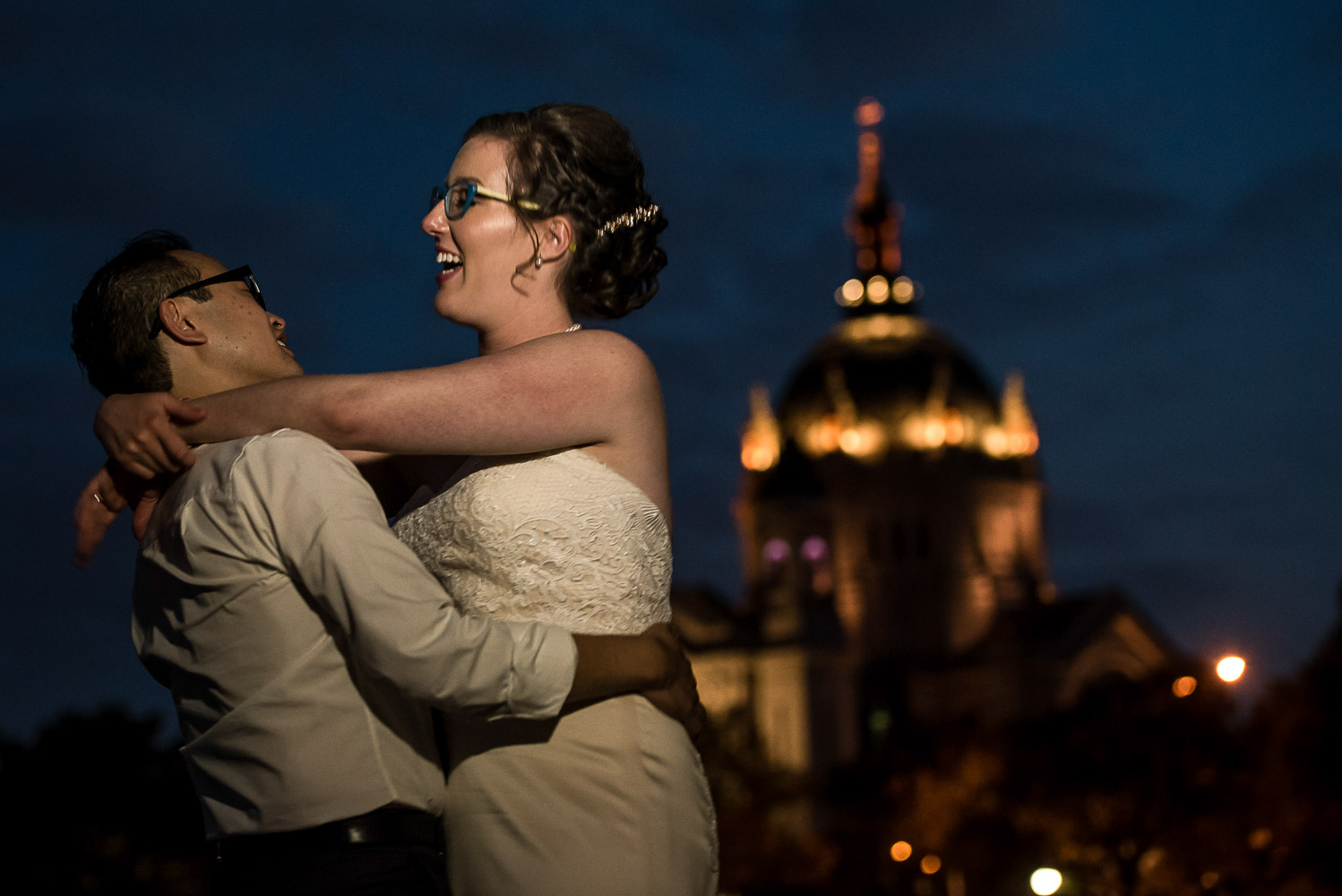 bride and groom hugging at night in front of the St Paul cathedral