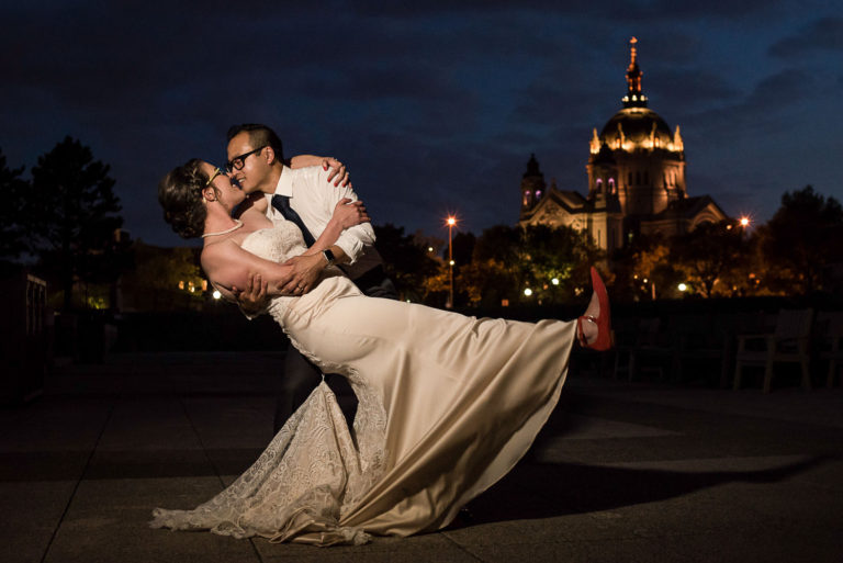 groom dipping the bride in front of the St Paul Cathedral