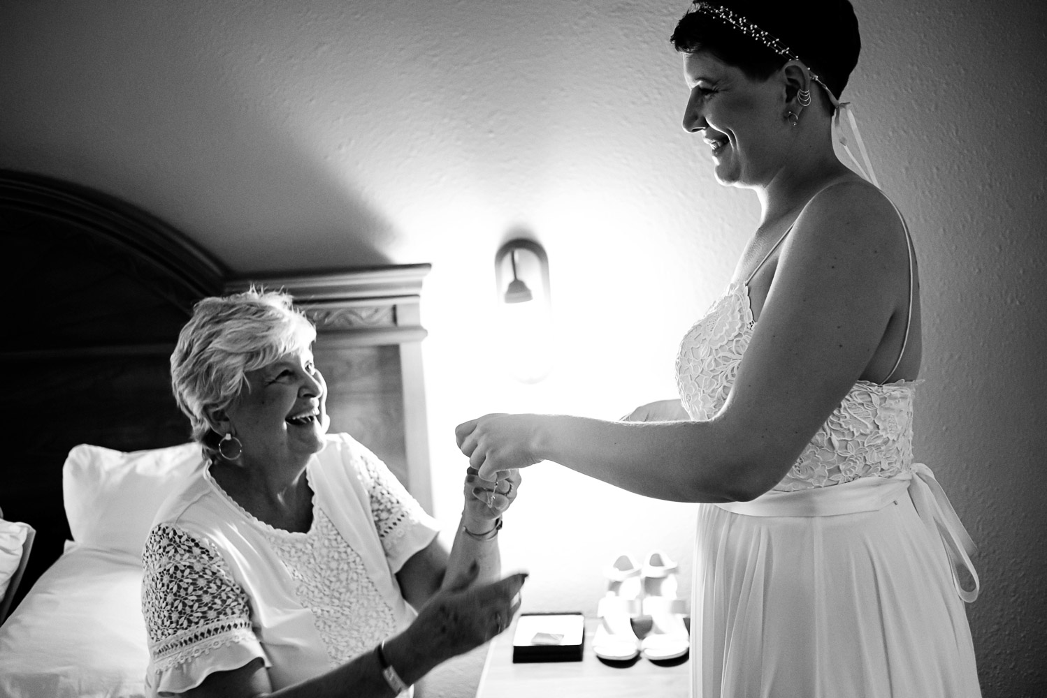 mom putting on bride's jewelery