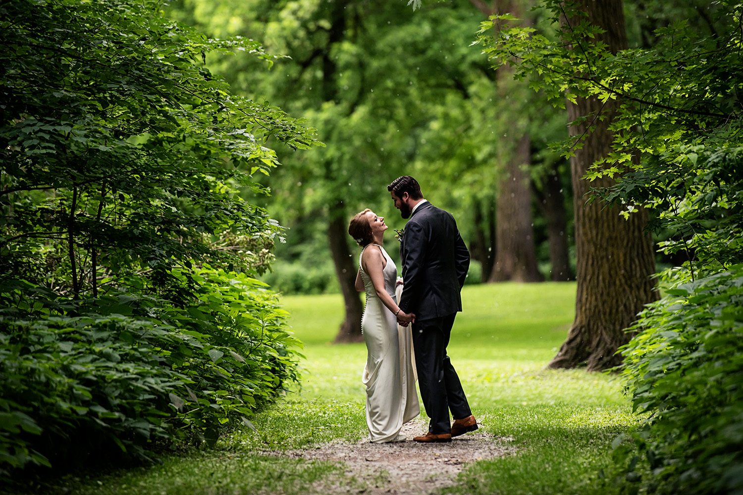 bride and groom in holding hands in the woods