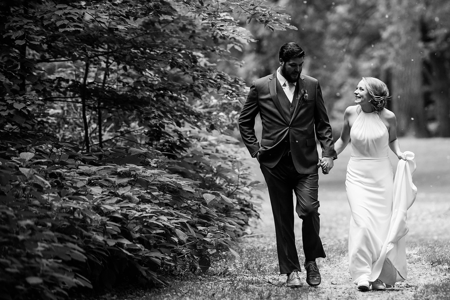 bride and groom walking through the woods on their wedding day