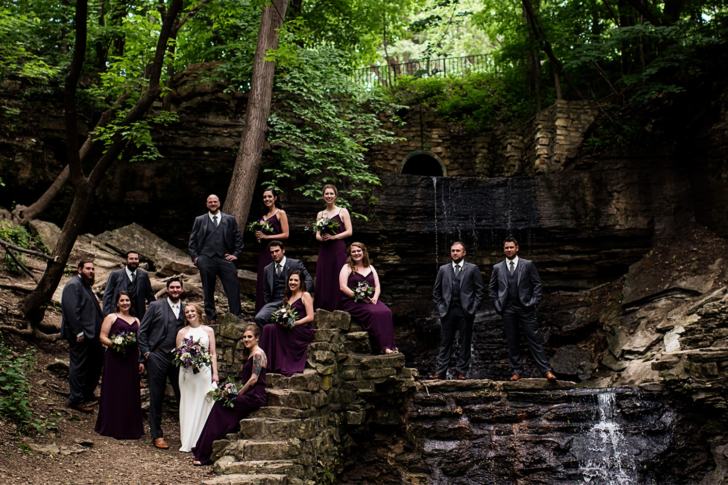 wedding party in burgundy dresses with the bride and groom at Hidden Falls in St Paul Minnesota 
