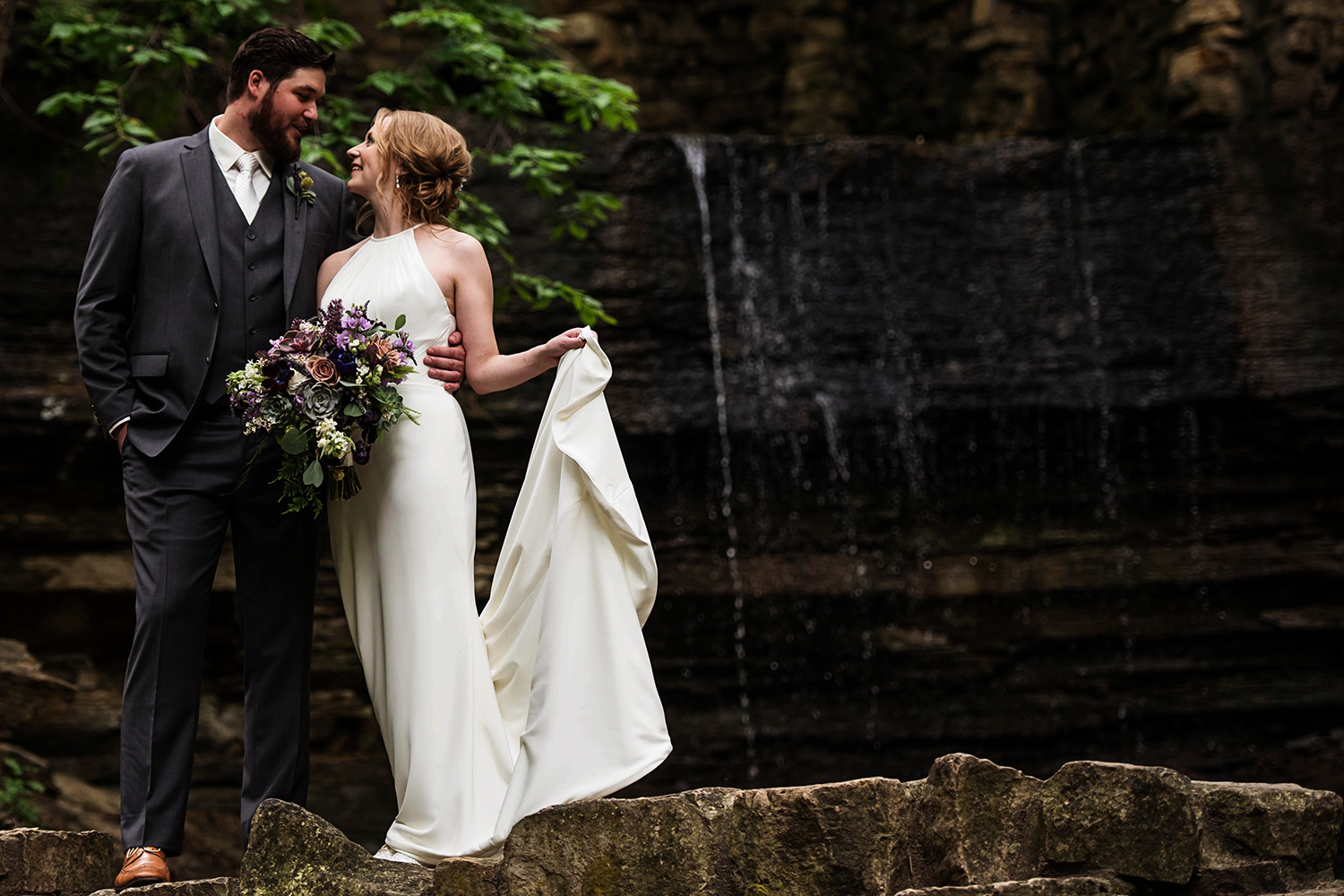 bride and groom in front of a water fall in Minnesota