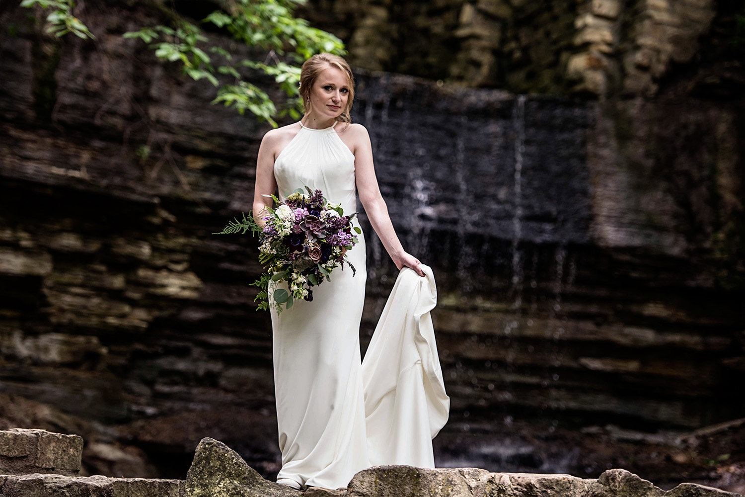 bride with her flowers in front of a waterfall in Minnesota
