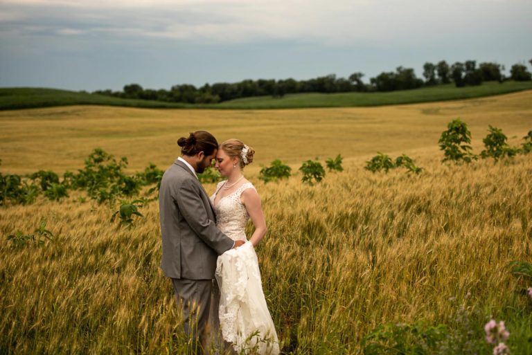 bride and groom hugging in a field in Minnesota