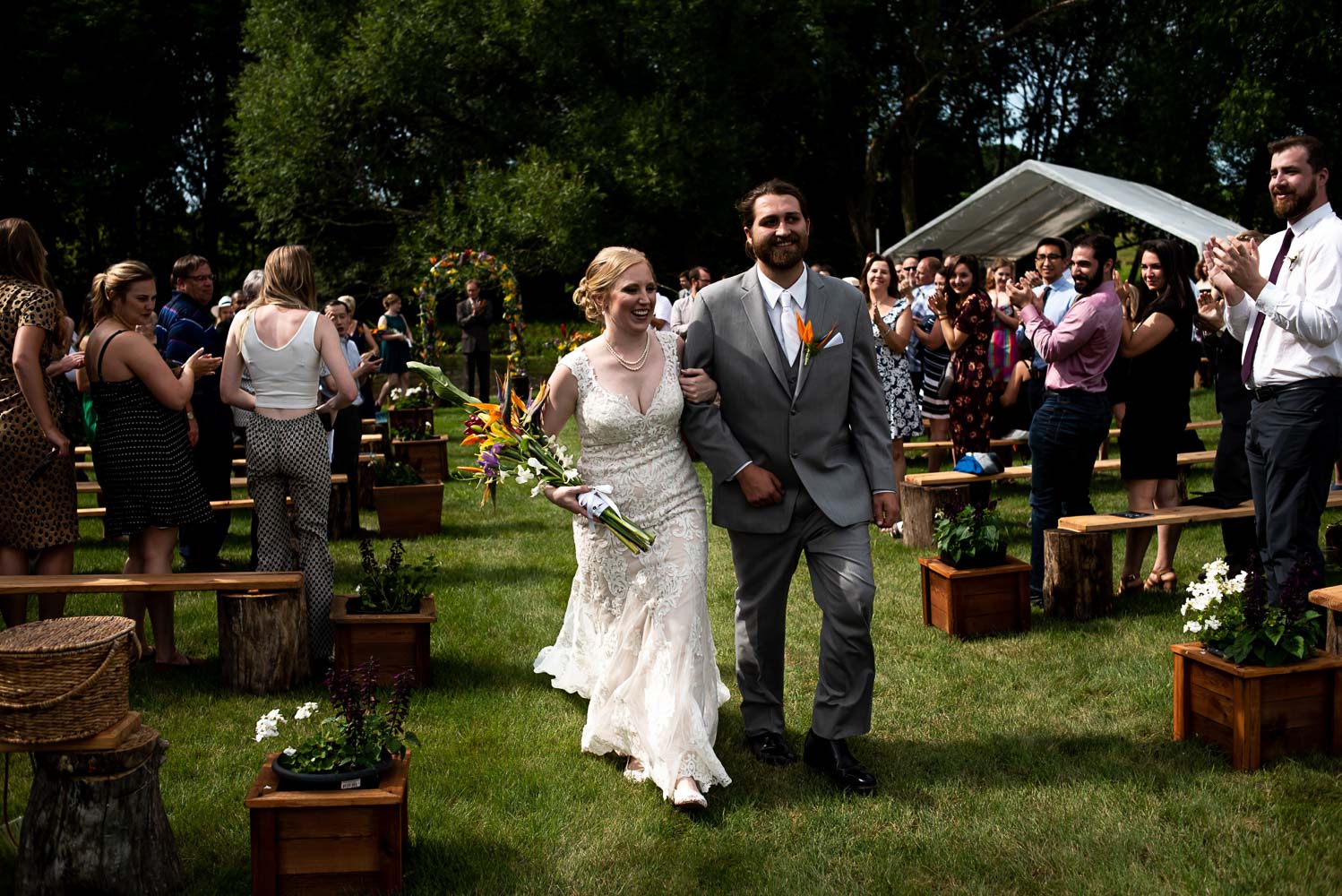 bride and groom walking down the aisle during the recessional after their summer wedding
