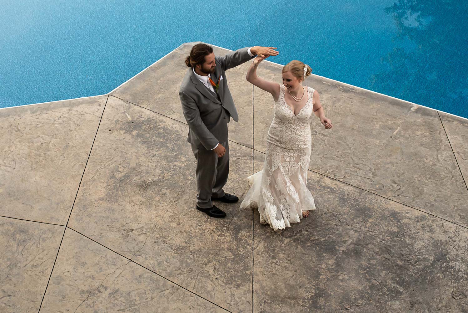 bride and groom first dance by the pool at their backyard summer wedding in Minnesota