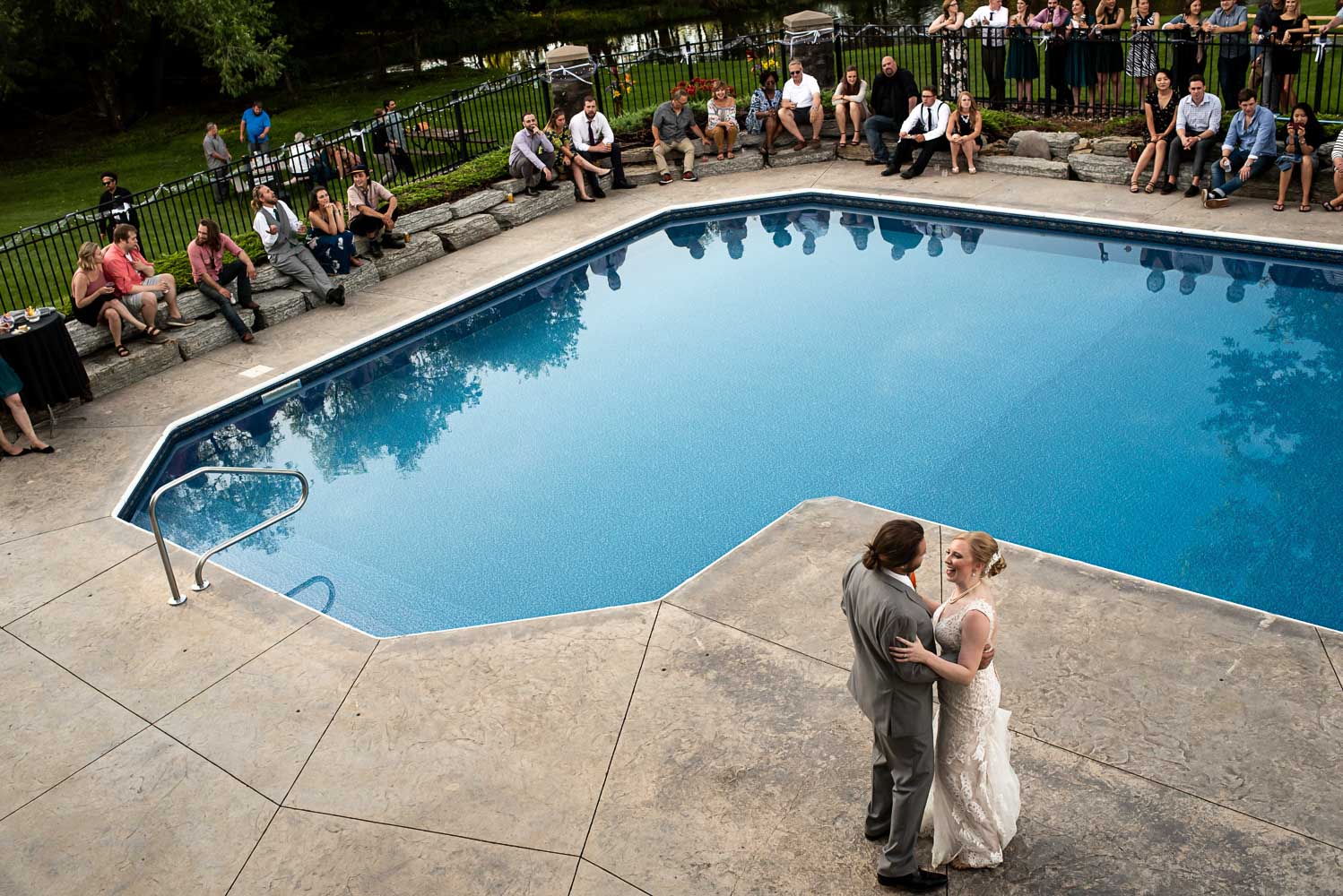 bride and groom first dance by the pool at their backyard summer wedding in Minnesota