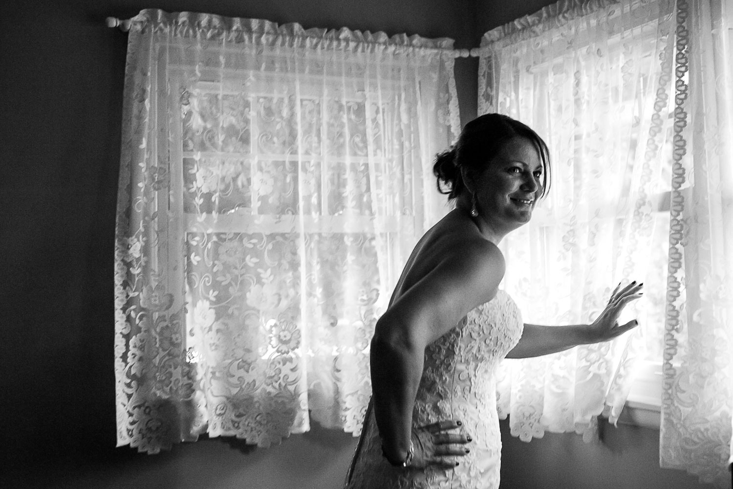 bride looking out the window on her wedding day in Iowa